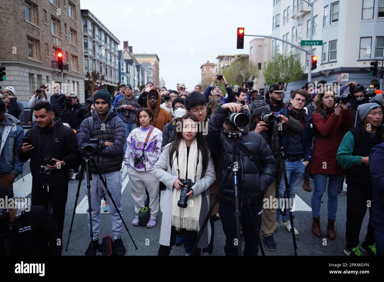 Menschen versammeln sich an der Kreuzung California Street und Gough Street und machen Fotos für den Sonnenaufgang. Die aufgehende Sonne verläuft zwischen der California Street und der Gough Street in San Francisco. Die Sonne rammt an den Gebäuden vorbei und erhebt sich über die Bay Bridge. Sie findet vom 8. April bis zum 10. April statt und geschieht zweimal im Jahr. Am 8. April versammelten sich Hunderte von Menschen an der Kreuzung von California Street und Gough Street. Viele von ihnen sind mit professioneller Fotoausrüstung ausgestattet und fotografieren den Sonnenaufgang mitten auf der Straße. Stockfoto