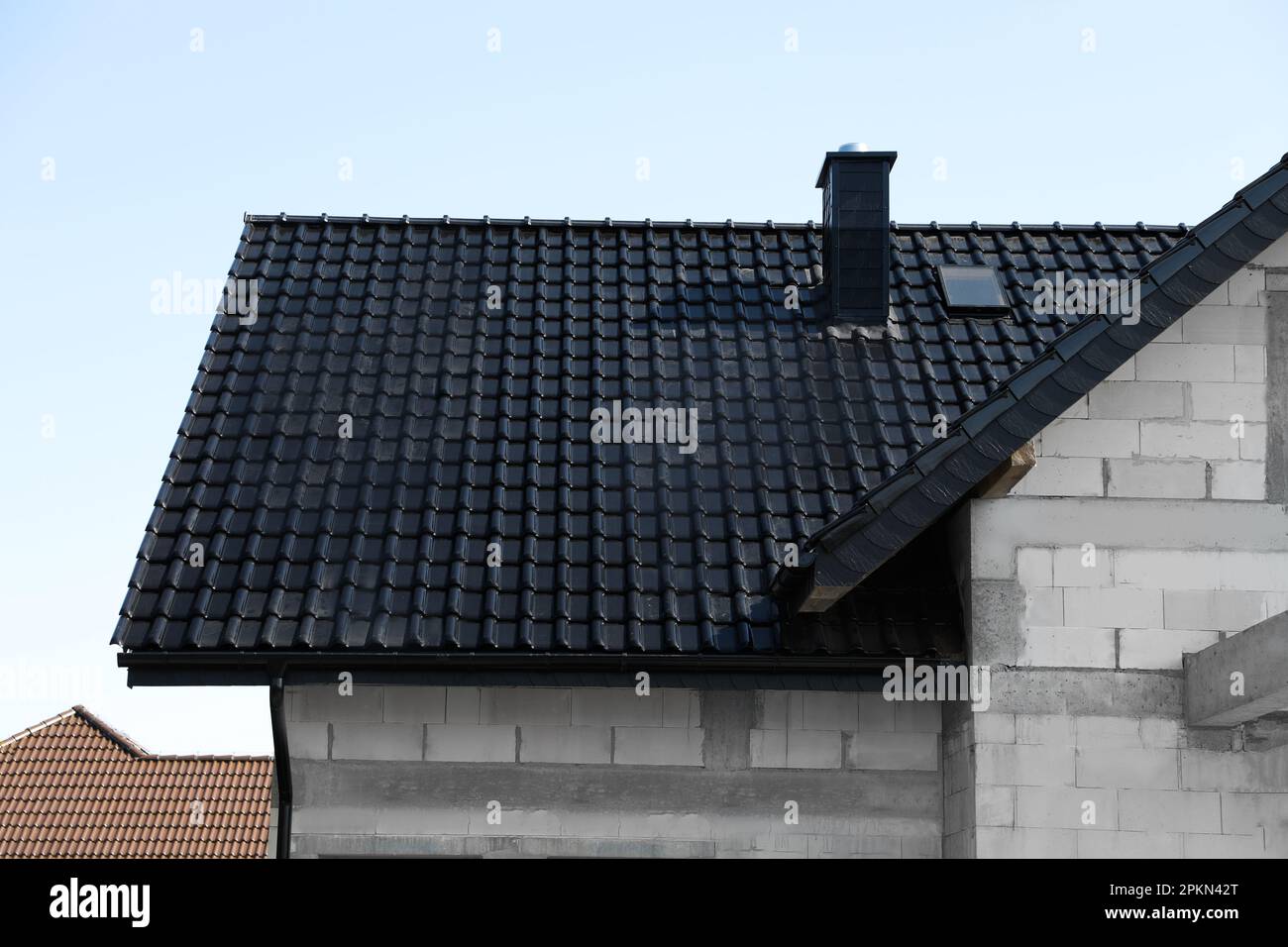 Unvollendetes Haus mit schwarzem Dach am blauen Himmel Stockfoto