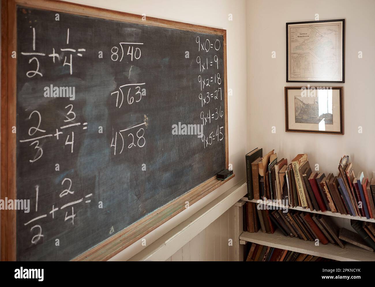 Innenansicht eines restaurierten antiken Schulhauses mit einem Raum und einer Tafel mit Mathematikübungen. Stockfoto