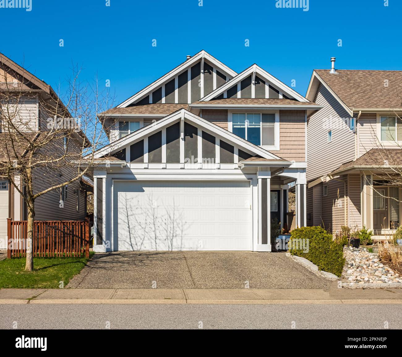 Außenansicht des Real Estate Front House an einem sonnigen Tag. Großes maßgeschneidertes Luxushaus mit schön gestaltetem Vorgarten und Auffahrt zur Garage in den Vororten Stockfoto