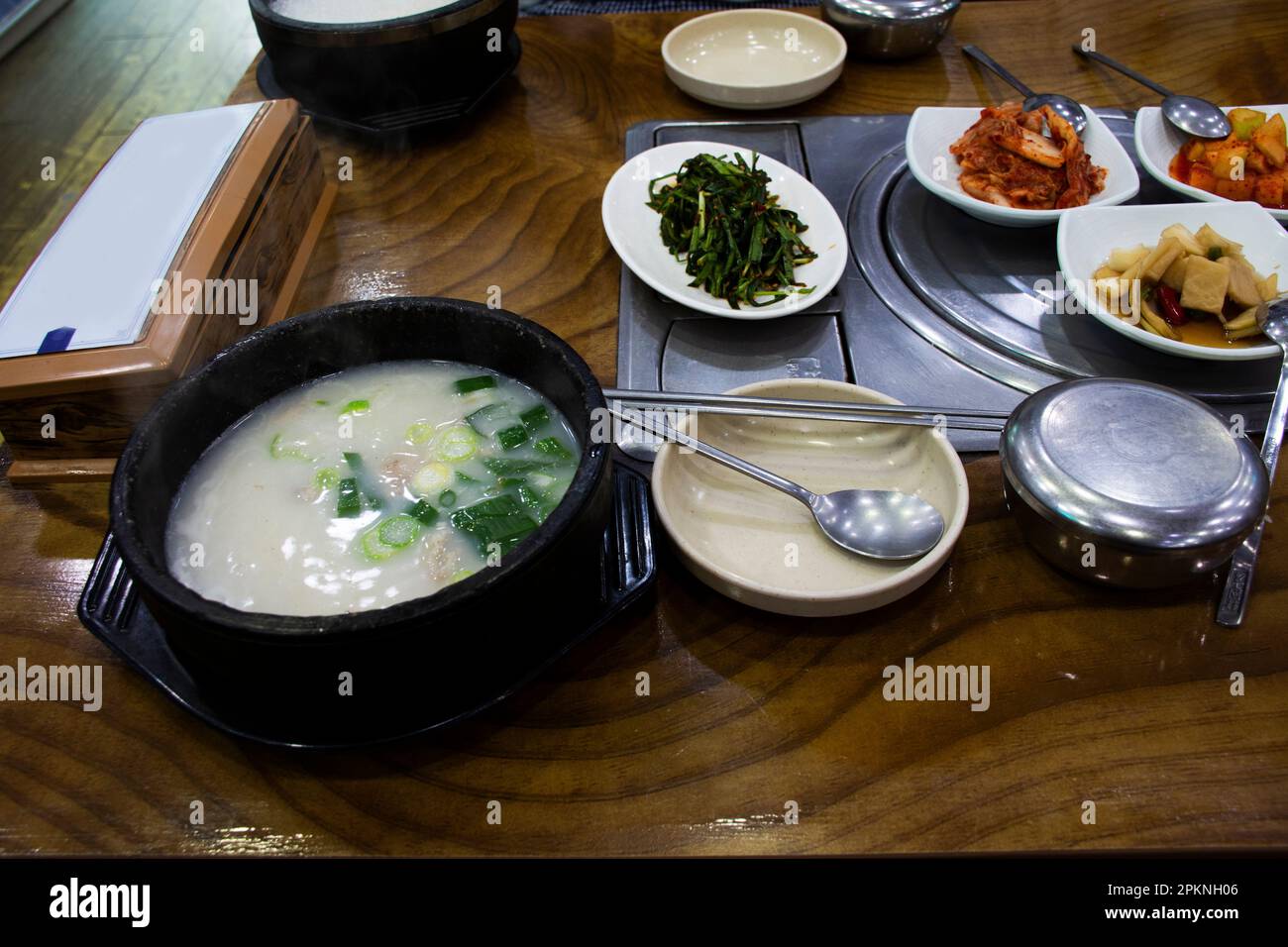 Lokale traditionelle koreanische Gourmetküche auf der Straße Schweinefleisch Rippchen Porridge Reissuppe mit Beilagen Würzmittel für koreanische Reisende besuchen A Stockfoto