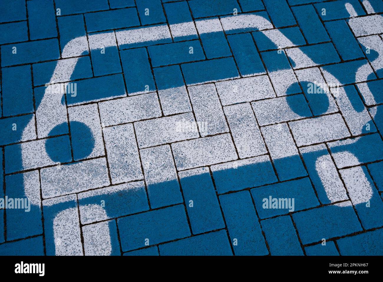 Elektroauto-Symbol auf blauem Boden einer Ladestation Stockfoto