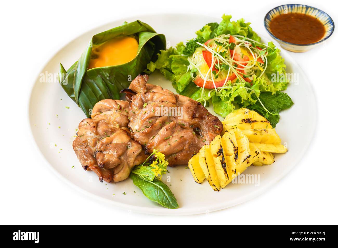 Vietnamesisches Hühnchen mit entbeinten Beinen mit Babymais unter Käse, Salat und gegrillter Ananas Stockfoto
