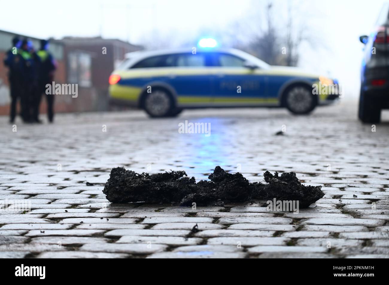Hamburg, Deutschland. 09. April 2023. Polizeibeamte blockieren den Bereich eines Großbrandes in Hamburg-Rothenburgsort über einen weiten Bereich, während Feuerteile auf einer Straße liegen. Aufgrund der starken Rauch- und Gasentwicklung mit möglichen chemischen Komponenten hat die örtliche Polizei eine offizielle Gefahrenwarnung ausgegeben. Kredit: Jonas Walzberg/dpa/Alamy Live News Stockfoto