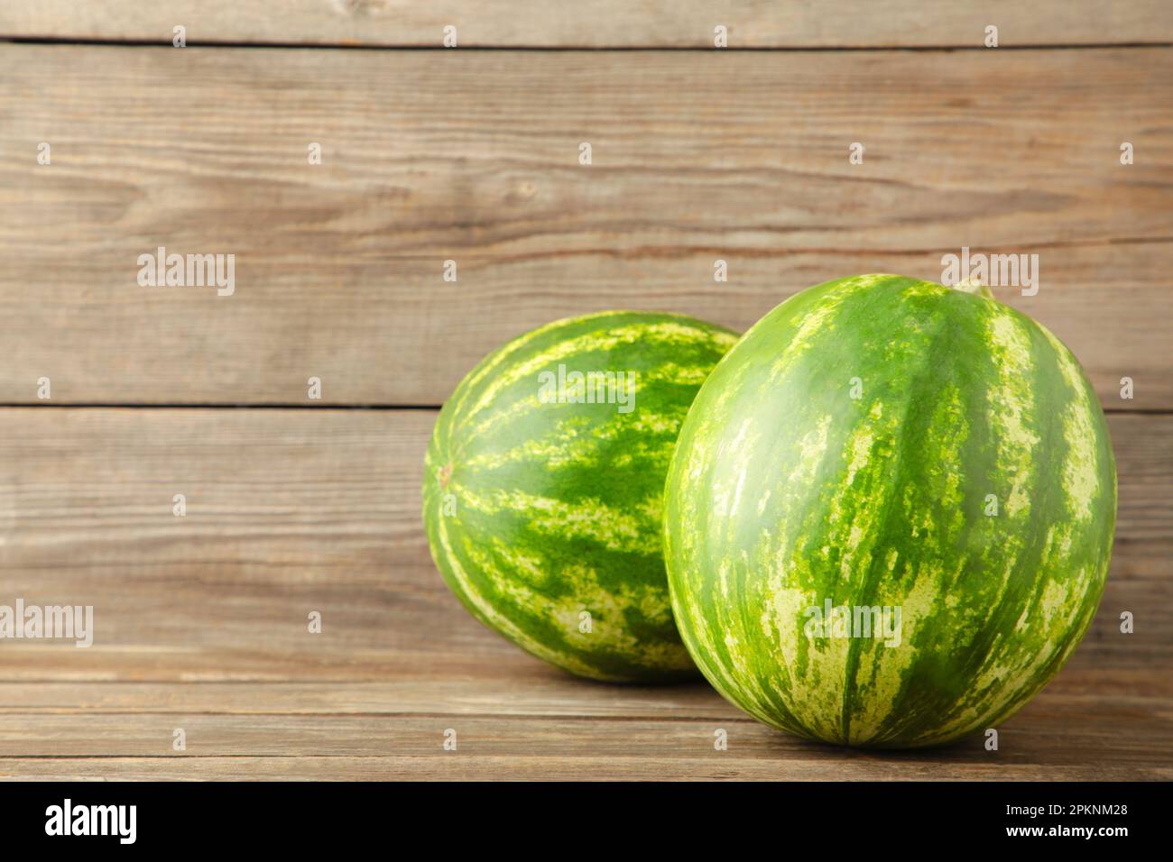 Zwei frische Wassermelonen auf grauem Hintergrund mit Kopierraum. Draufsicht Stockfoto