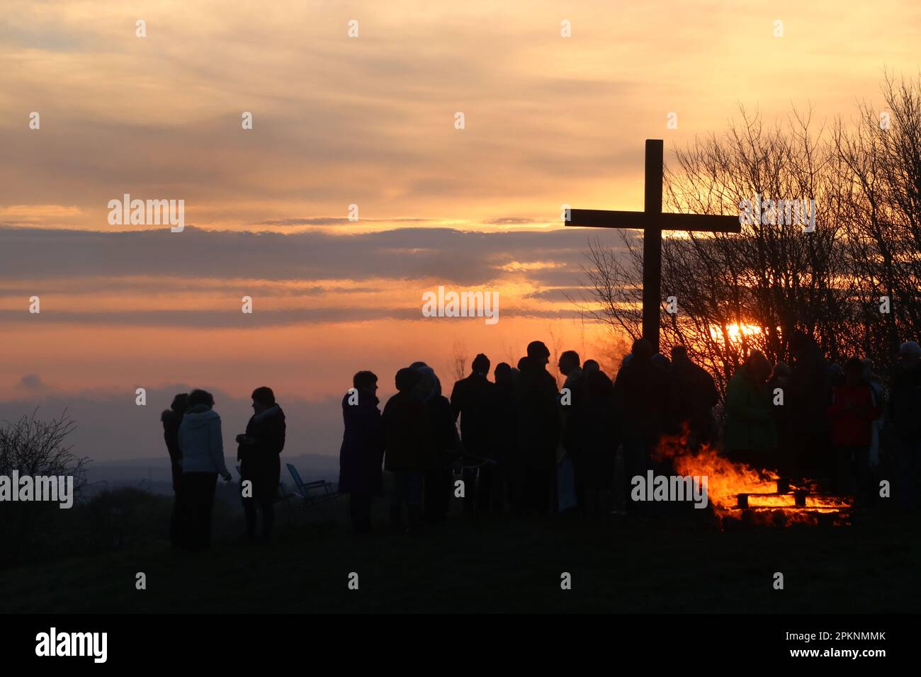 Silhouetten von Menschen versammelten sich am Osterkreuz bei Sonnenaufgang, nachdem sie die Morgenkommunion am Ostertag, dem 9. April 2023, gefeiert hatten. Stockfoto