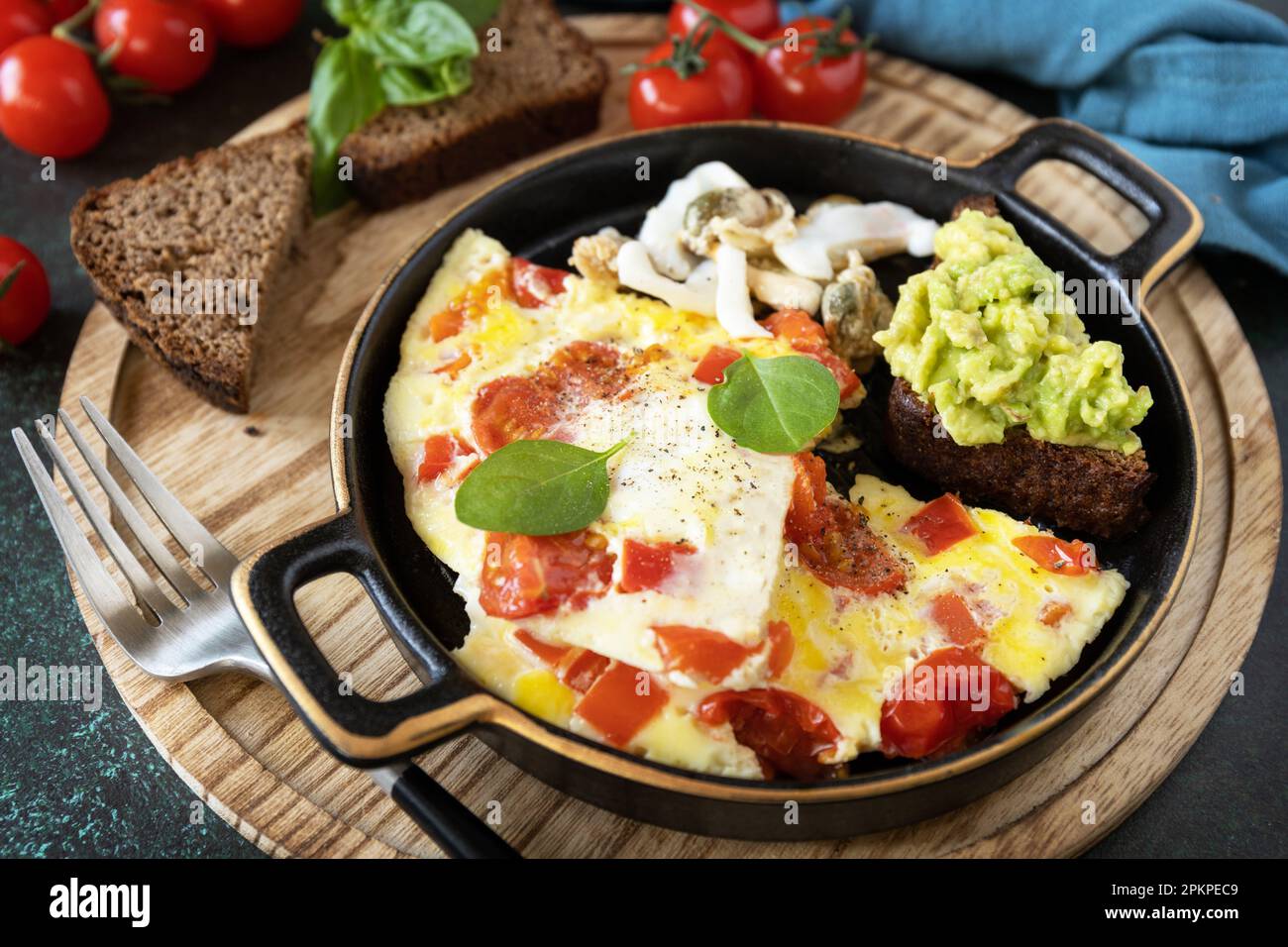 Omelette oder Omelette mit Gemüsepaprika und Tomaten, Toastbrot mit Avocado und salzhaltigen Meeresfrüchten. Gesundes Keto Diät kohlenhydratarmes Frühstück. Stockfoto
