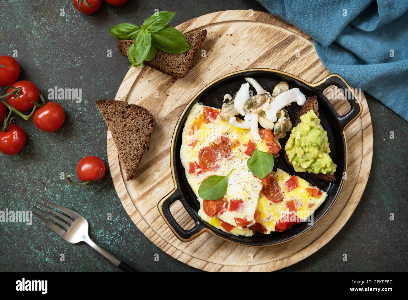 Gesundes Keto Diät kohlenhydratarmes Frühstück. Omelette oder Omelette mit Gemüsepaprika und Tomaten, Toastbrot mit Avocado und salzhaltigen Meeresfrüchten. Blick von oben Stockfoto