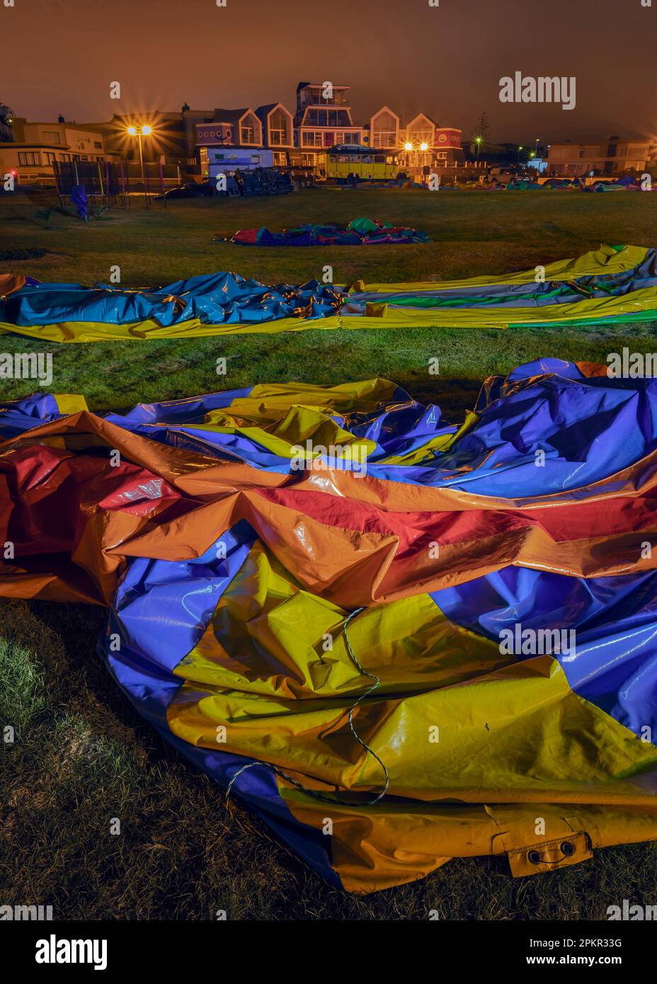 Eine lustige Kindermesse, die vor Sonnenaufgang an der Uferpromenade von Swakopmund fotografiert wurde. Die Straßenlaternen der Stadt erzeugen ein seltsames orangefarbenes Licht Stockfoto