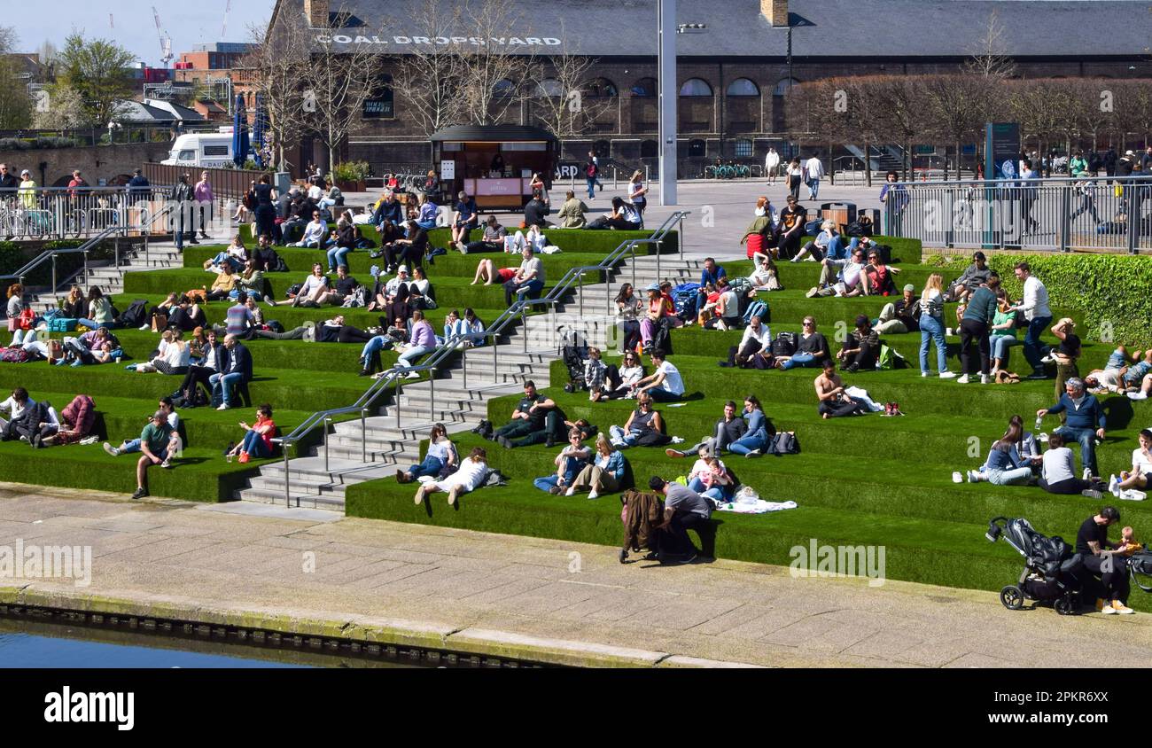 London, England, Großbritannien. 9. April 2023. An einem warmen Frühlingstag genießen die Menschen die Sonne auf dem künstlichen Gras neben dem Regent's Canal am Granary Square in King's Cross. (Kreditbild: © Vuk Valcic/ZUMA Press Wire) NUR REDAKTIONELLE VERWENDUNG! Nicht für den kommerziellen GEBRAUCH! Kredit: ZUMA Press, Inc./Alamy Live News Stockfoto