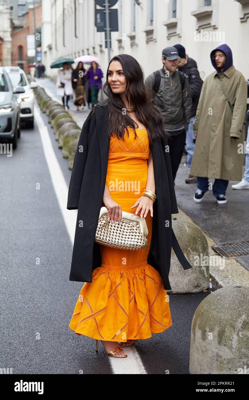 MAILAND, ITALIEN - 26. FEBRUAR 2023: Frau mit orangefarbenem Kleid und  schwarzem Mantel vor der Modenschau Luisa Spagnoli, Mailand Fashion Week  Street Style Stockfotografie - Alamy