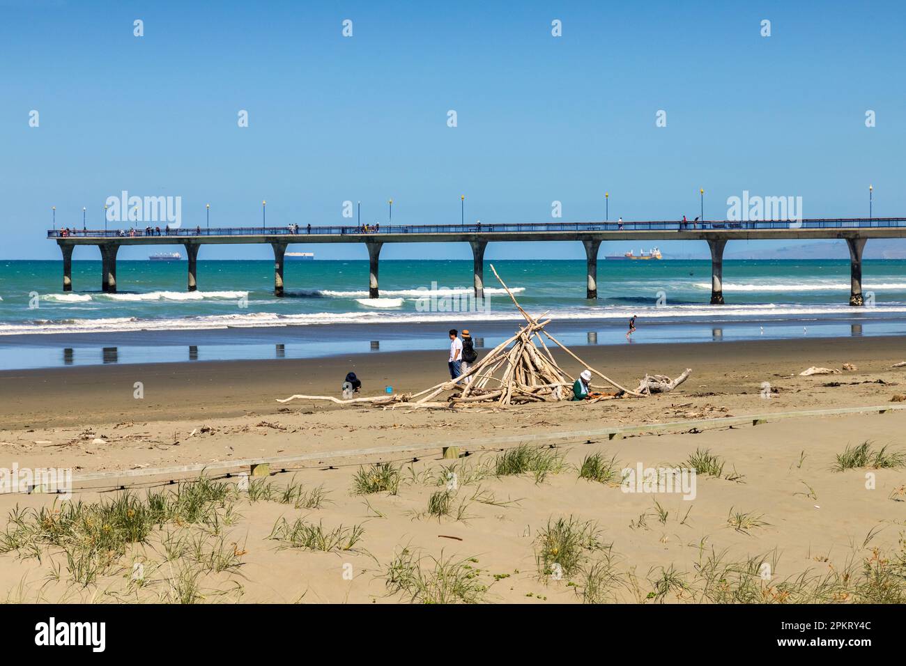 31. Dezember 2022: Christchurch, Neuseeland - New Brighton Beach, mit Stäbchenschutz oder Strandschutz, und New Brighton Pier. Stockfoto