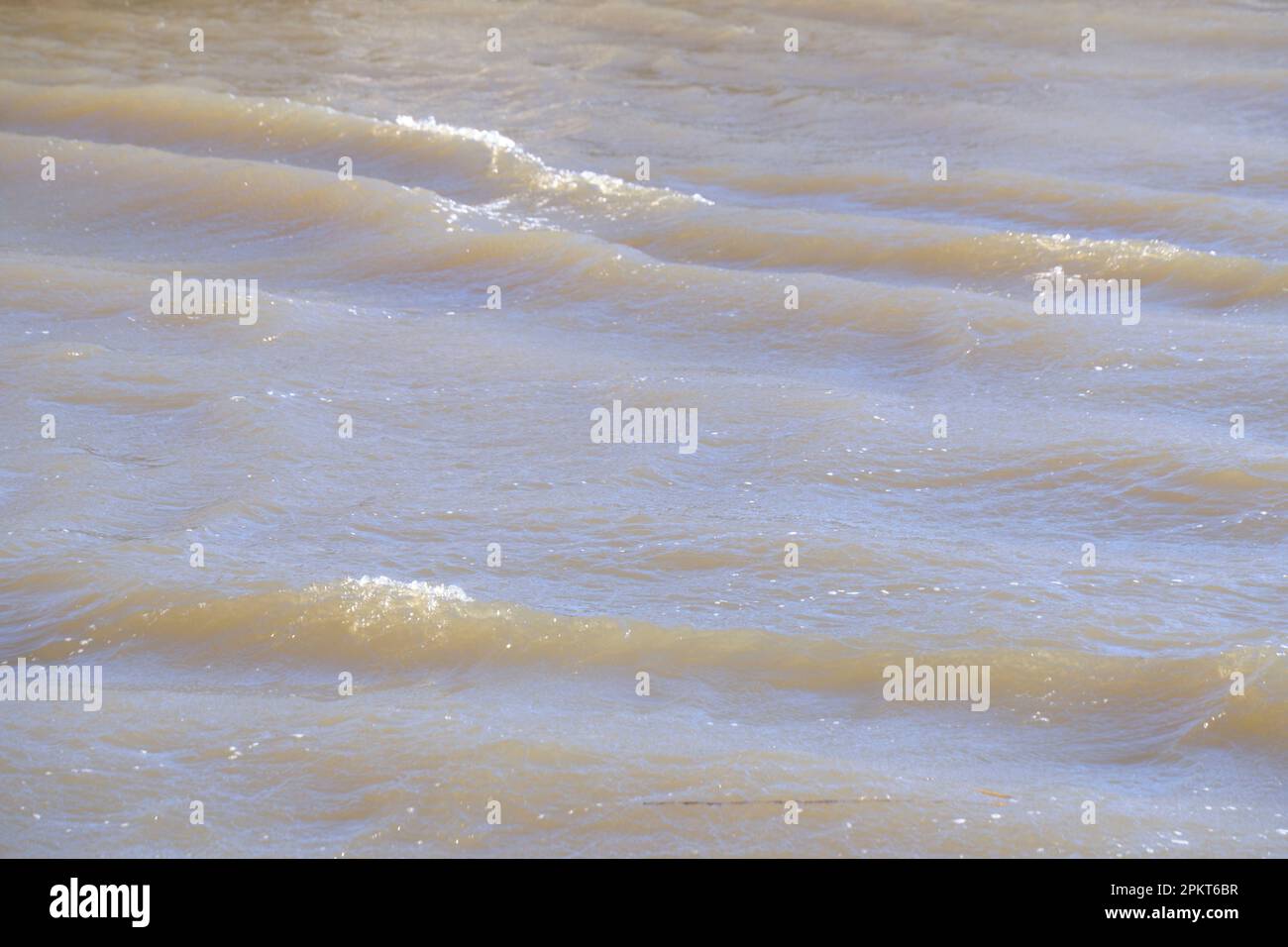 Wellen von der starken Windfläche des schlammigen Flusses Stockfoto