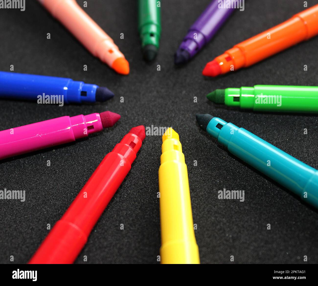 Farbenfrohe Stifte mit Filzspitze ohne Stiftkappen wie Ein Strahl auf Einem schwarzen Oberflächenfoto Stockfoto