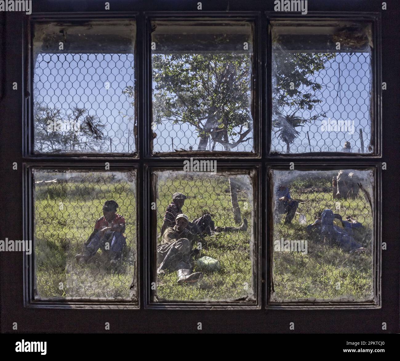 Landarbeiter machen Mittagspause von ihrer Arbeit auf dem Bauernhof Norwood. Das Bild wurde durch das Fenster eines Lagerraums aufgenommen. Stockfoto