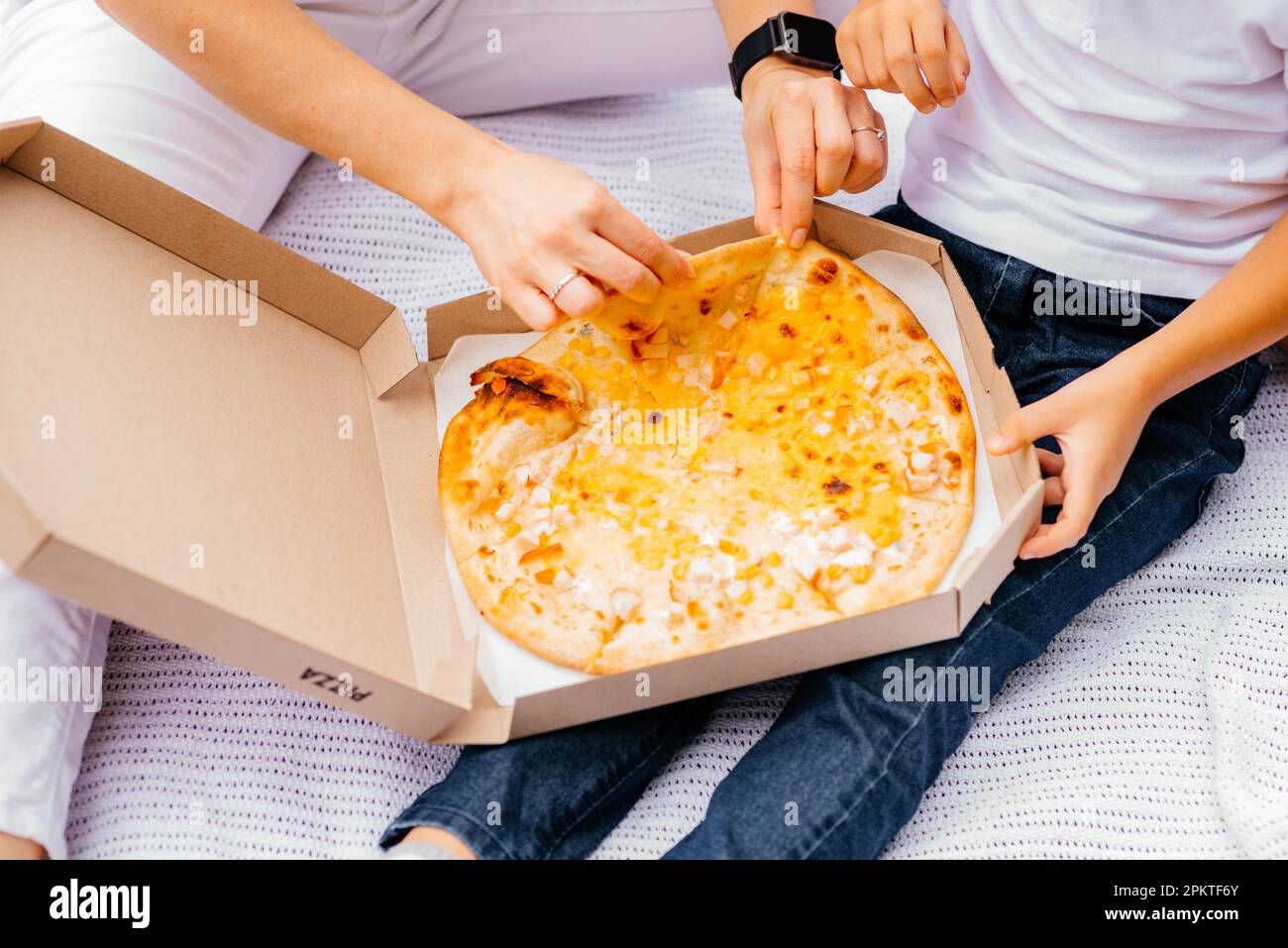 Pizza-Picknick. Mom und Sohn essen Pizza. Köstliche Pizza, vier ... Pizza-Picknick. Mom und Sohn essen Pizza. Köstliche Pizza, vier ...