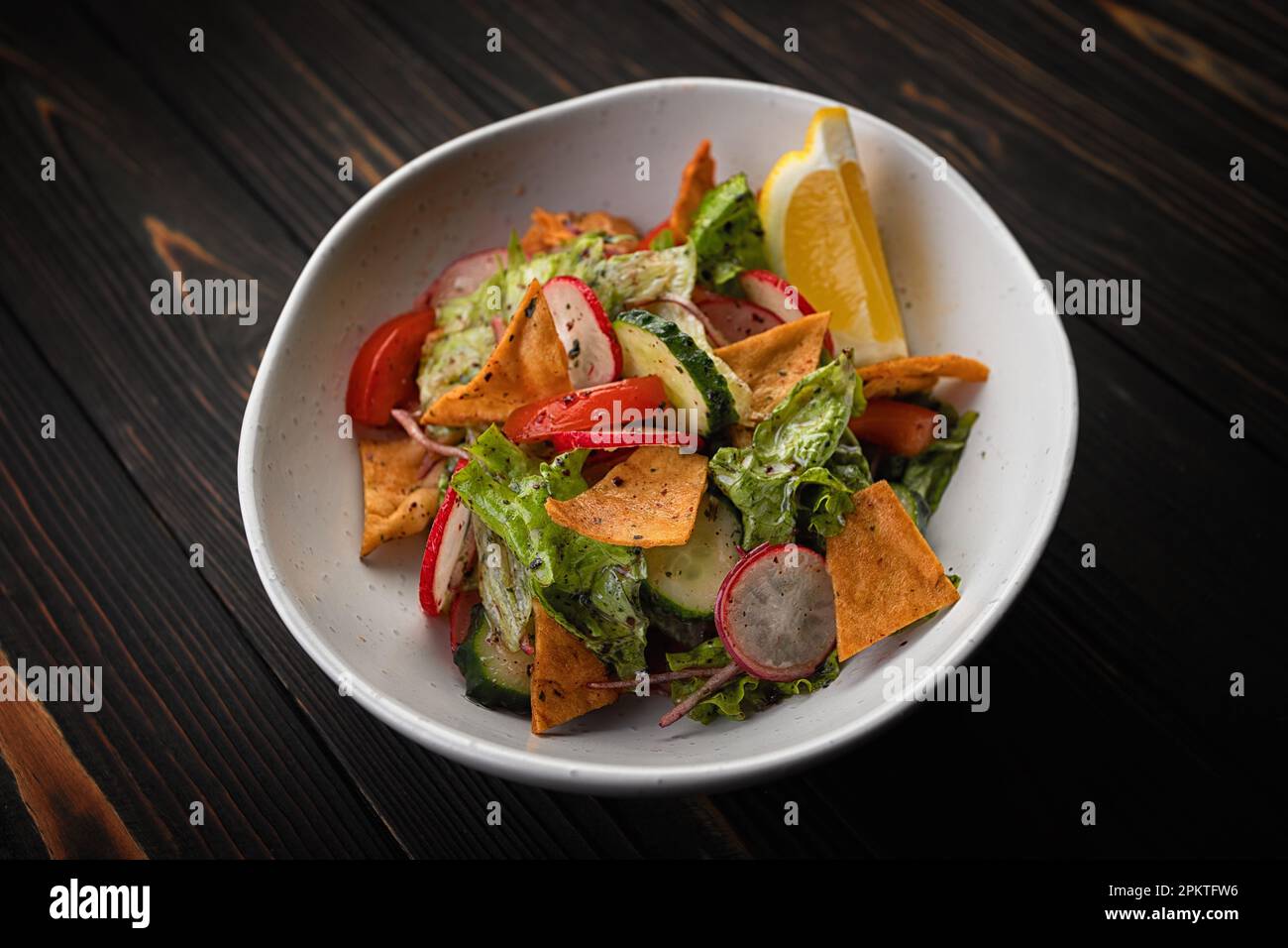 Gesunder Salat mit knusprigen Chips und frischem Gemüse auf Holzhintergrund Stockfoto