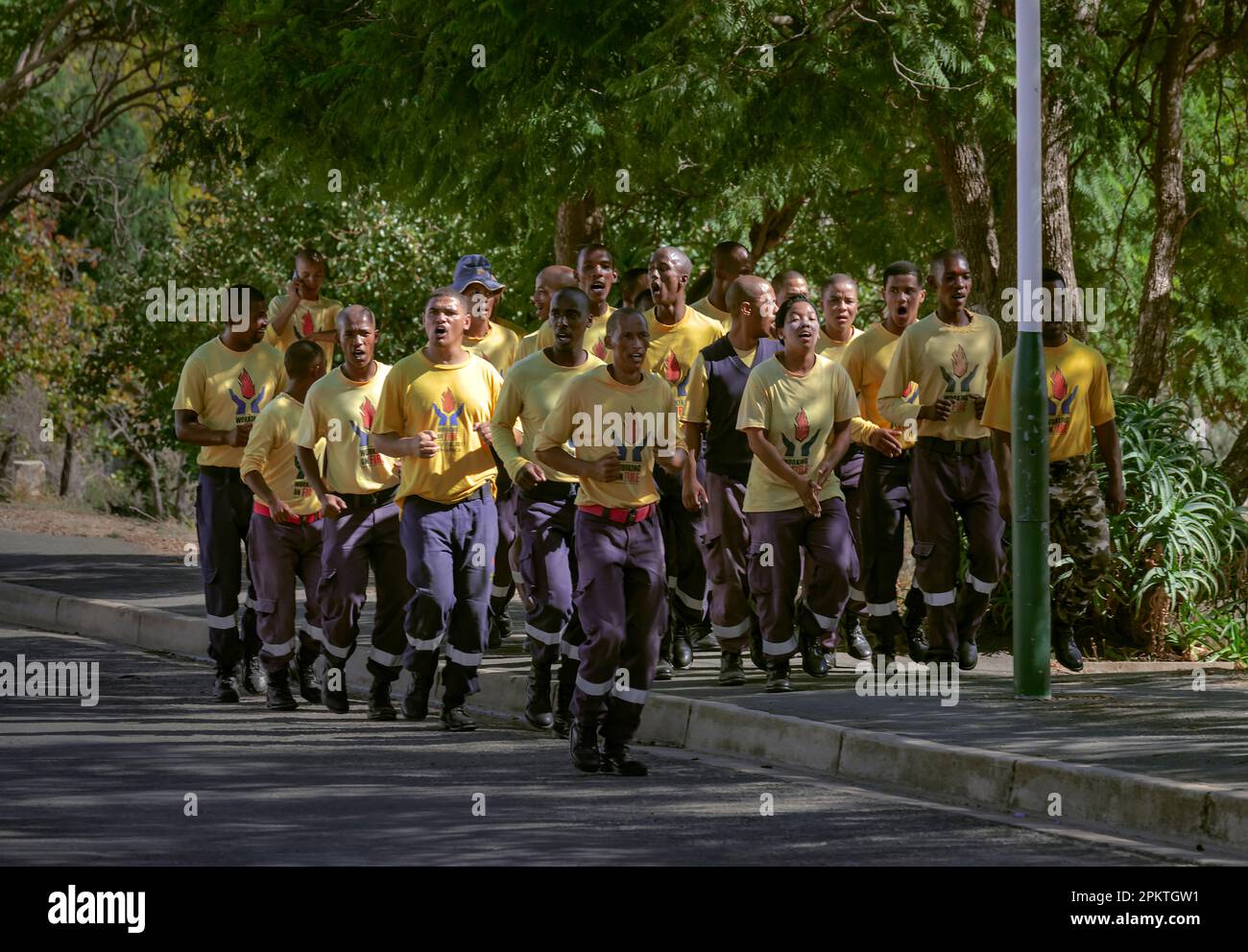 Eine Gruppe von Kommunalbeamten, die für das Feuer arbeiten, joggen durch die Straßen von Uniondale. Stockfoto