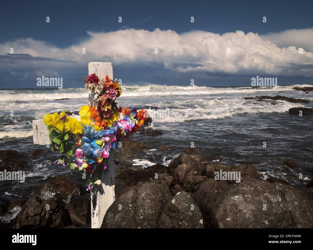 Plastikblumen schmücken ein Kreuz, um an den Ort zu erinnern, an dem ein älterer Fischer an den Felsen in der Nähe von Gouritzmond ertrunken ist. Südküste Von Kap. Sout Stockfoto