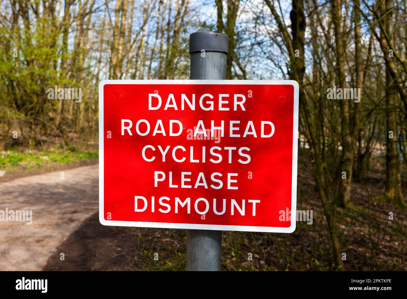 Ein Warnschild, das Radfahrer anweist, auf einem Radweg in Großbritannien auszusteigen Stockfoto