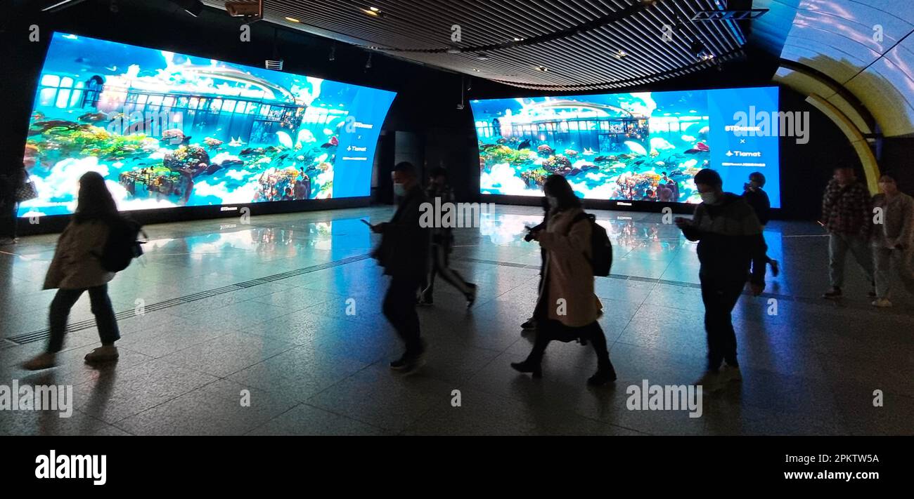 SHANGHAI, CHINA - 7. APRIL 2023 - Fußgänger passieren die künstlich erzeugten Landschaftsmalereien von Tiamat und STDecaux, die auf einer großen Leinwand eingeloggt sind Stockfoto