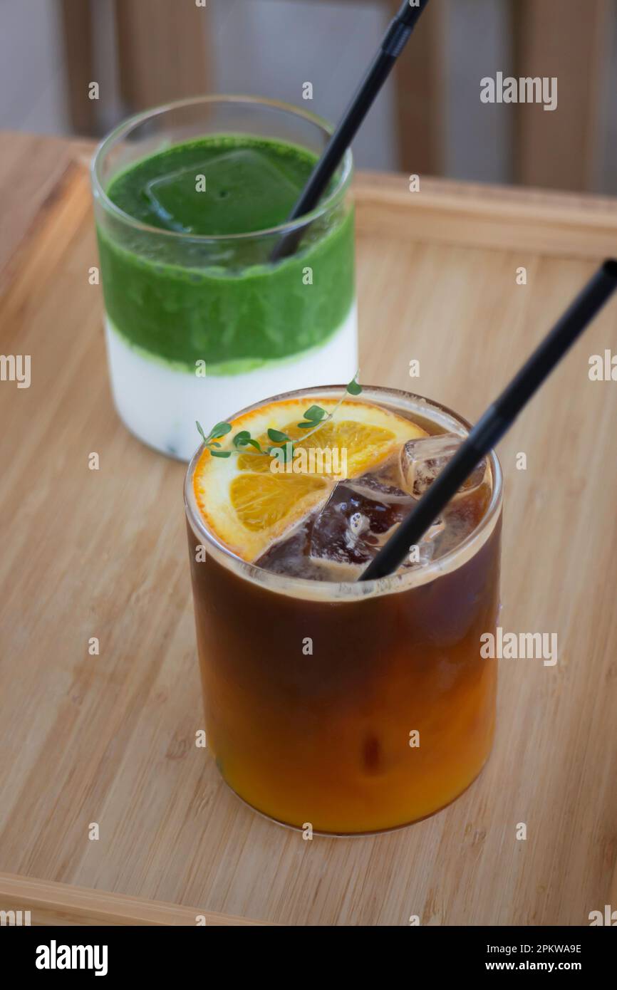 Eismatcha greentea und schwarzer Orangenkaffee auf Holztisch, Stockfoto Stockfoto
