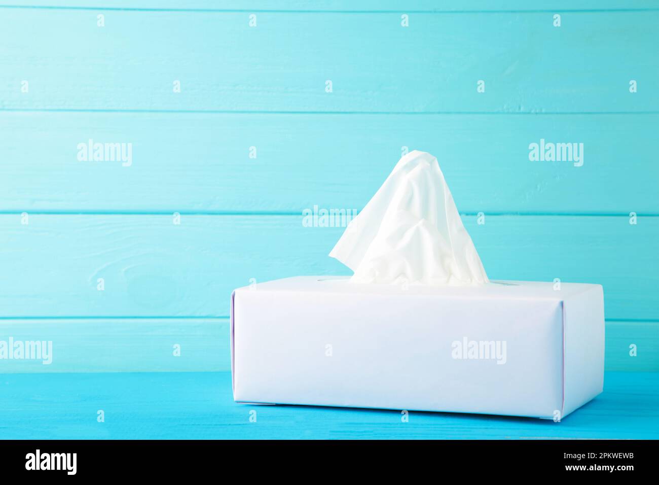Karton mit Papiertüchern auf blauem Hintergrund. Draufsicht Stockfoto