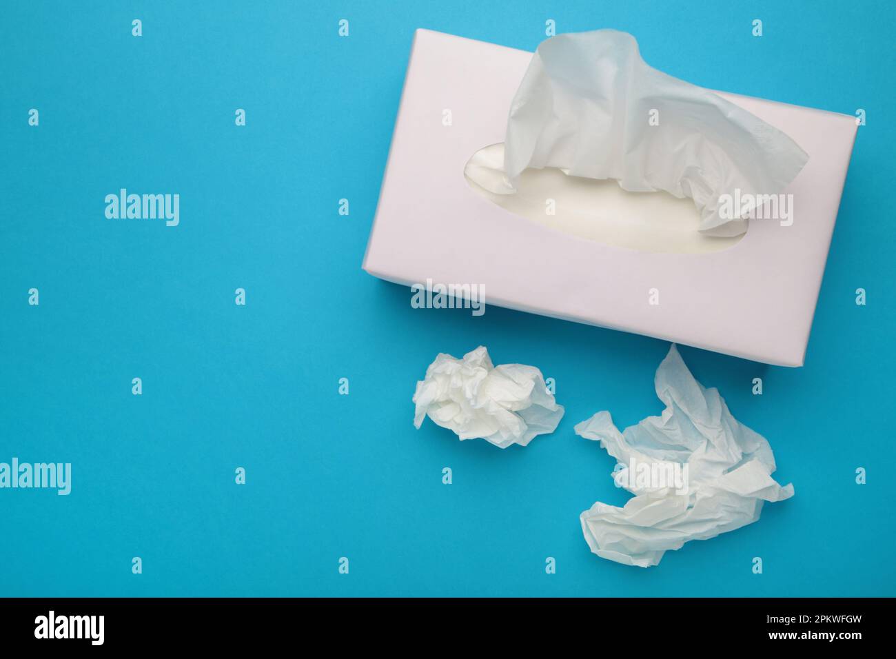 Karton mit Papiertüchern auf blauem Hintergrund. Draufsicht Stockfoto