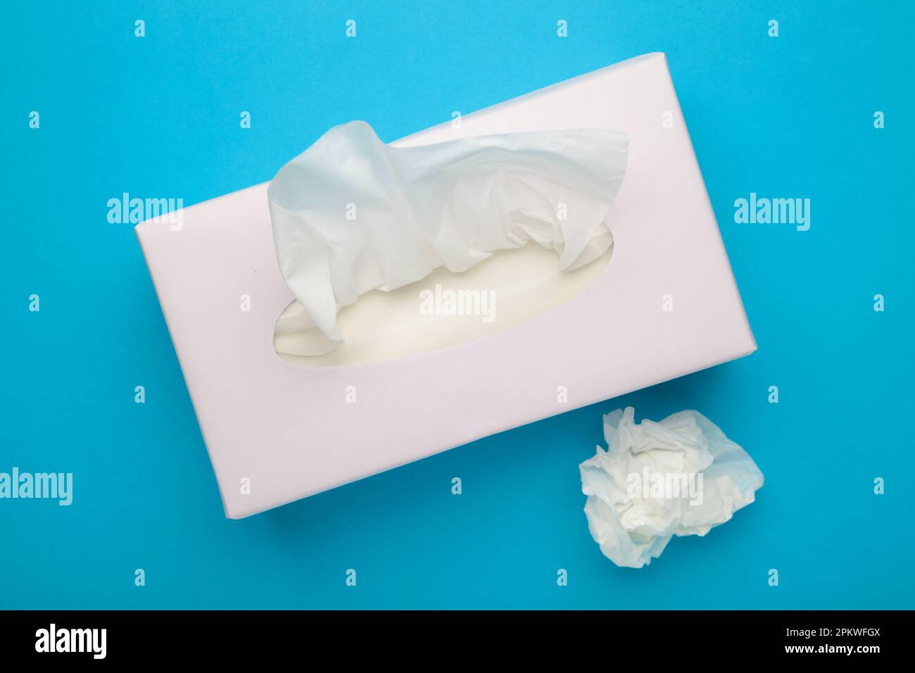 Karton mit Papiertüchern auf blauem Hintergrund. Draufsicht Stockfoto