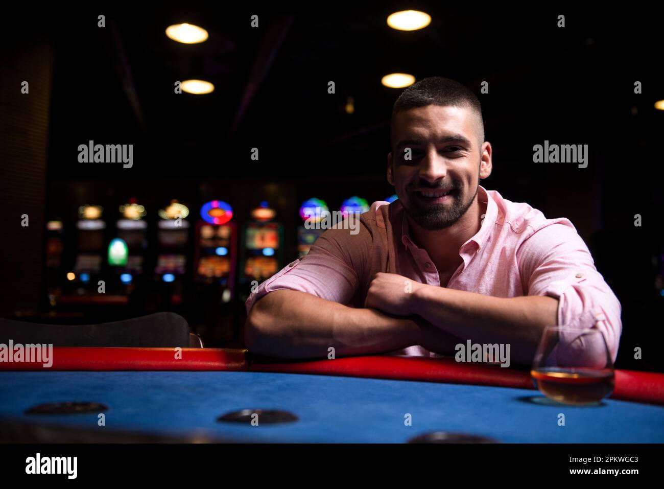 Junger Mann spielt Blackjack Behind Table im Casino Stockfoto
