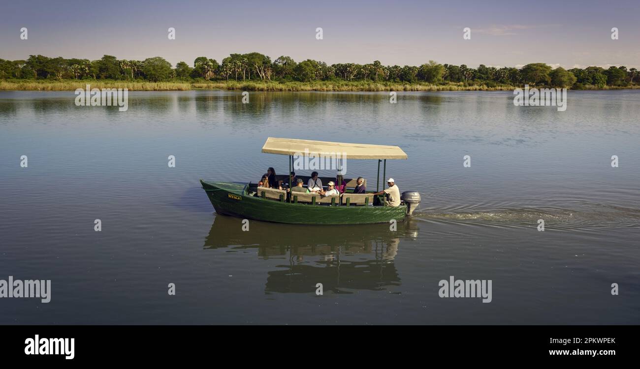 Ein Flussboot der Mvuu Wilderness Lodge fährt für eine Flusssafari auf dem Shire River im Liwonde Nationalpark ab. Stockfoto