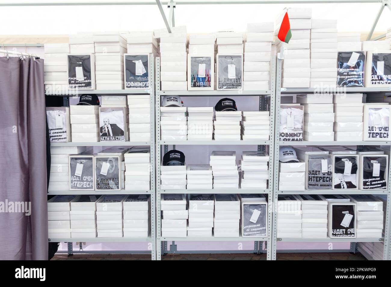 Grodno, Belarus - 30. Juni 2022: Regale mit verpackten Kleidungsstücken, auf denen Zitate des Präsidenten lukaschenko gedruckt sind. Souvenirkleidung und Hüte sind so Stockfoto