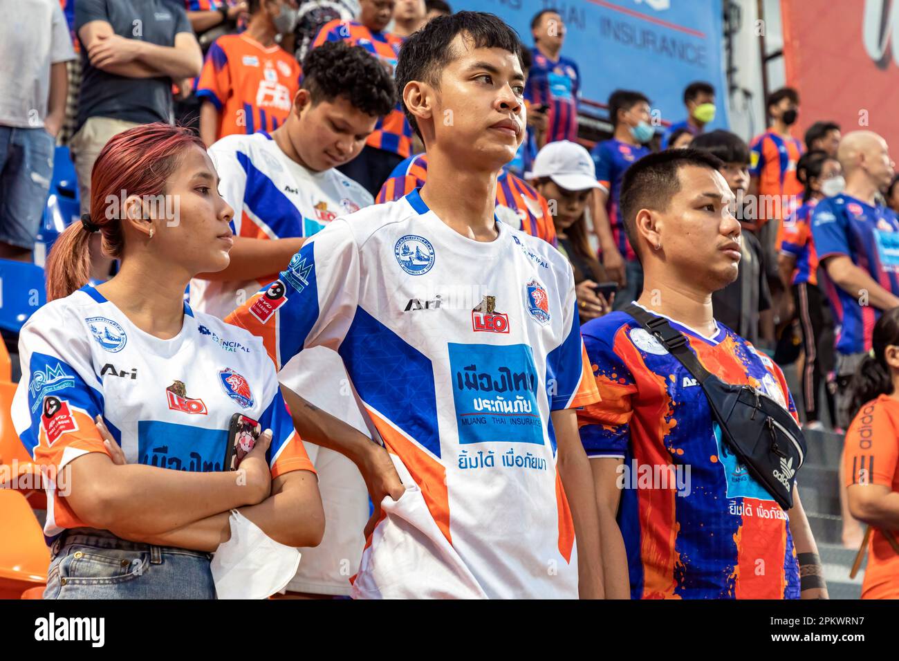 Fans und Zuschauer von Port F.C. stehen vor dem Spiel der thailändischen Fußballliga im PAT-Stadion, Khlong Toey, Bangkok, Thailand für die Nationalhymne Stockfoto
