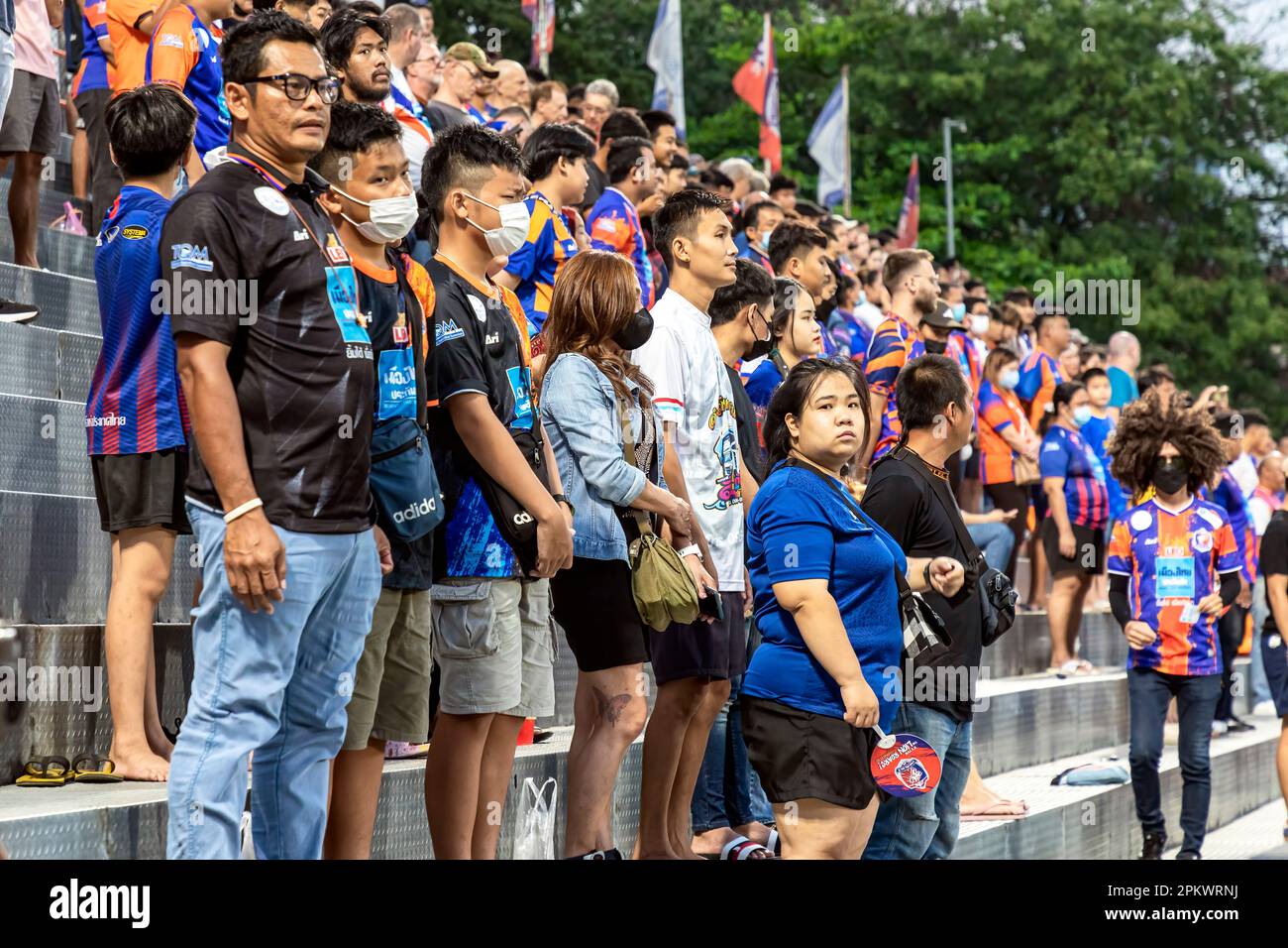 Fans und Zuschauer von Port F.C. stehen vor dem Spiel der thailändischen Fußballliga im PAT-Stadion, Khlong Toey, Bangkok, Thailand für die Nationalhymne Stockfoto