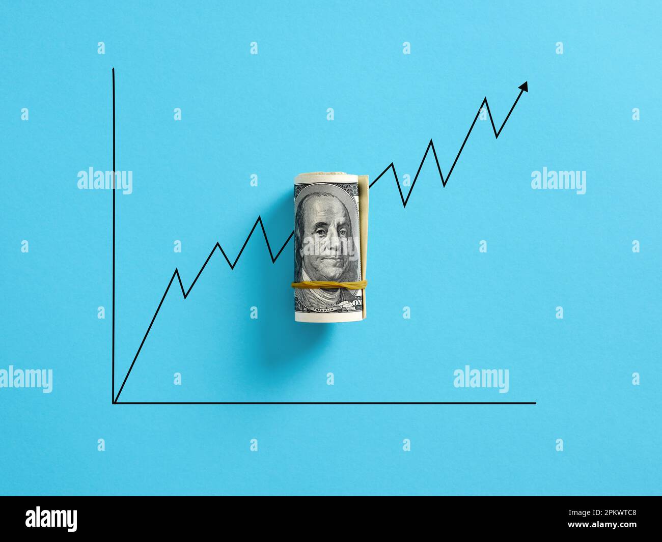 Ein Haufen US-Dollar-Geld mit einer zunehmenden Grafik auf blauem Hintergrund. Starkes Währungskonzept und Konzept der Wertsteigerung. Stockfoto