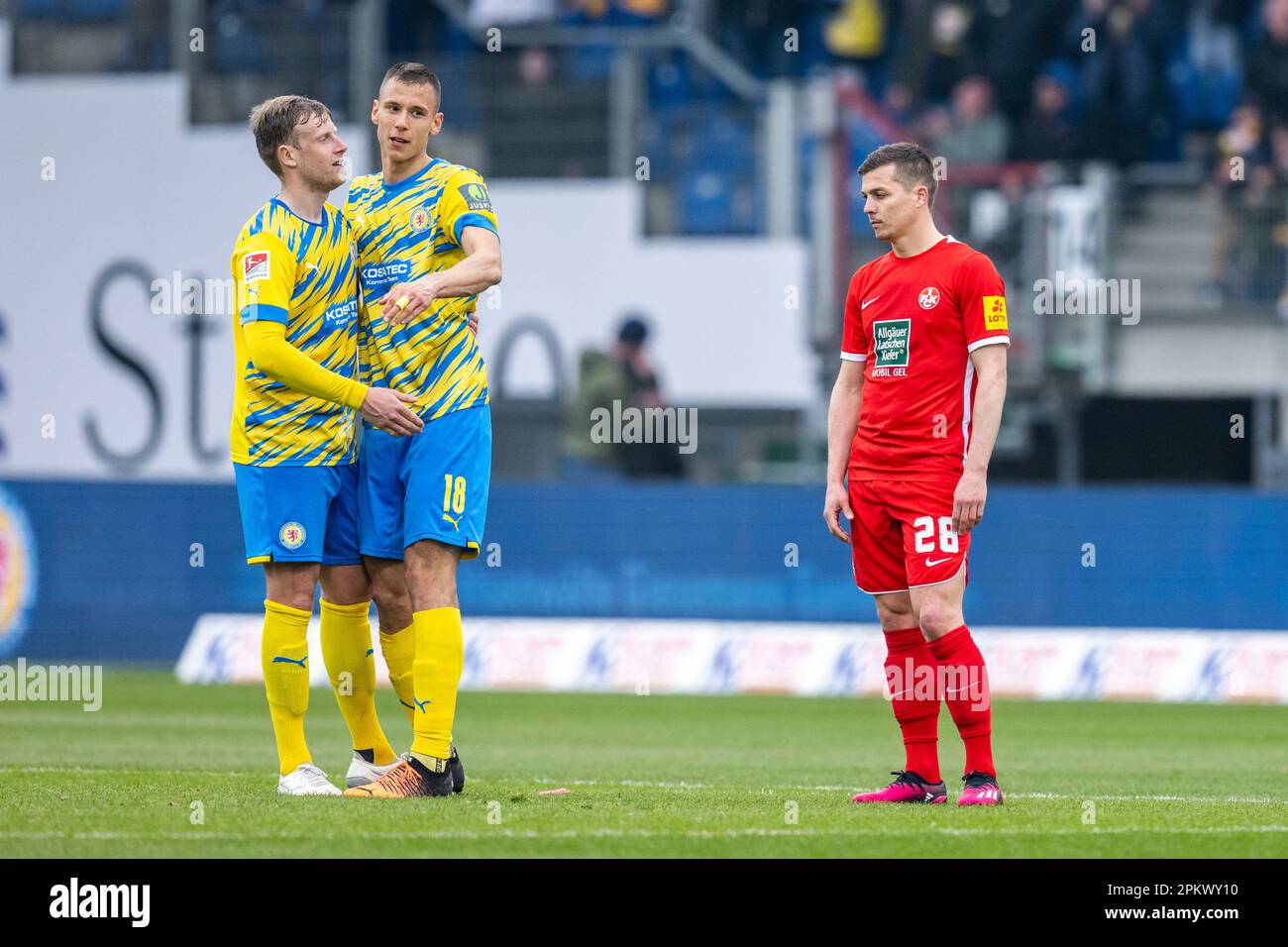 08. April 2023, Niedersachsen, Brunswick: Fußball: 2. Bundesliga, Eintracht Braunschweig - 1. FC Kaiserslautern, Matchday 27, Eintracht-Stadion: Braunschweigs Brian Behrendt (l-r) und Braunschweigs Filip Benkovic freuen sich über die letzte Pfeife, während Kaiserslauterns Nicolas de Preville enttäuscht ist. Foto: David Inderlied/dpa - WICHTIGER HINWEIS: Gemäß den Anforderungen der DFL Deutsche Fußball Liga und des DFB Deutscher Fußball-Bund ist es verboten, im Stadion aufgenommene Fotografien und/oder das Spiel in Form von Sequenzbildern und/oder videoähnlichen ph-werten zu verwenden oder verwenden zu lassen Stockfoto