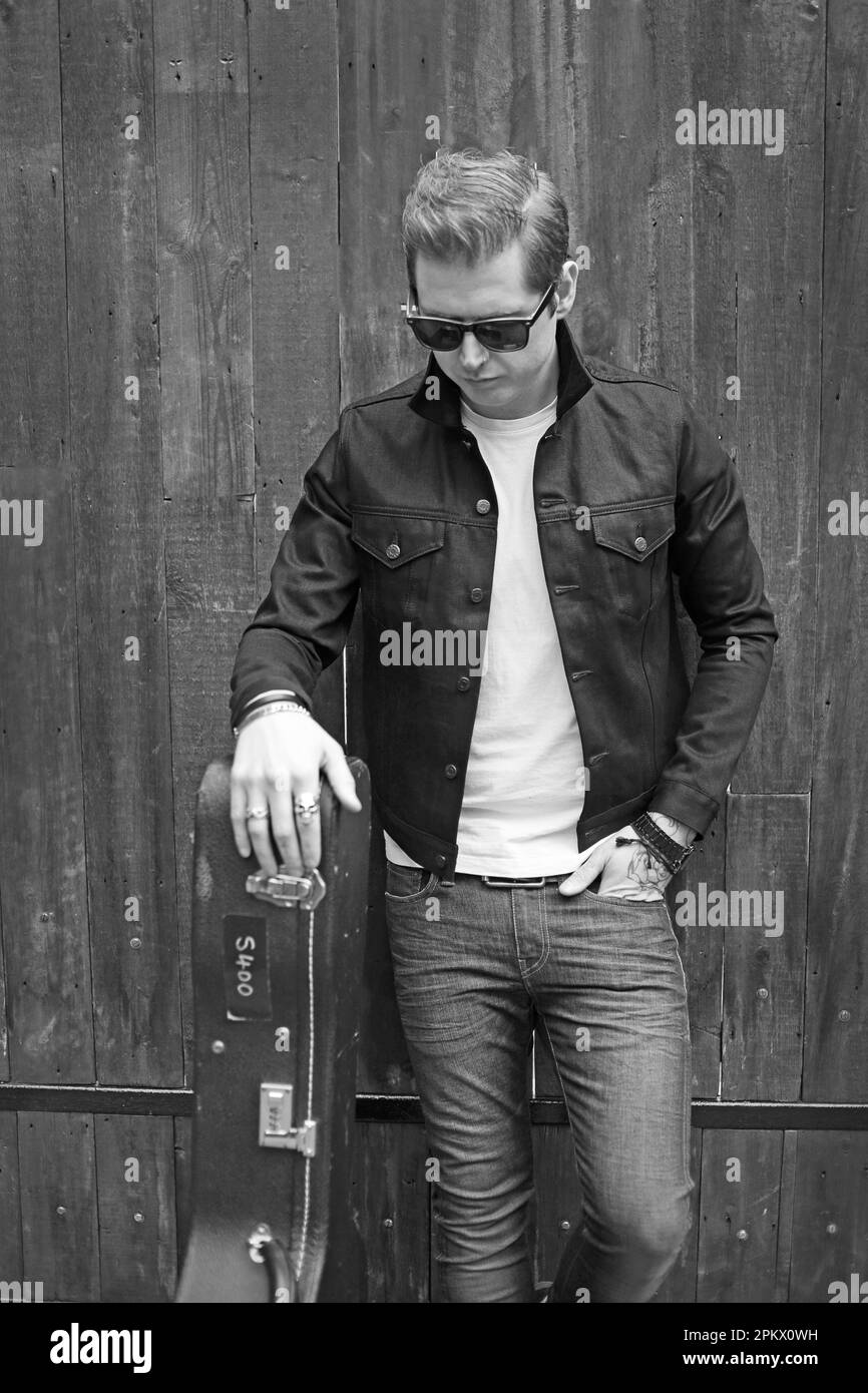 Junger Mann mit Gitarrenkoffer Stockfoto