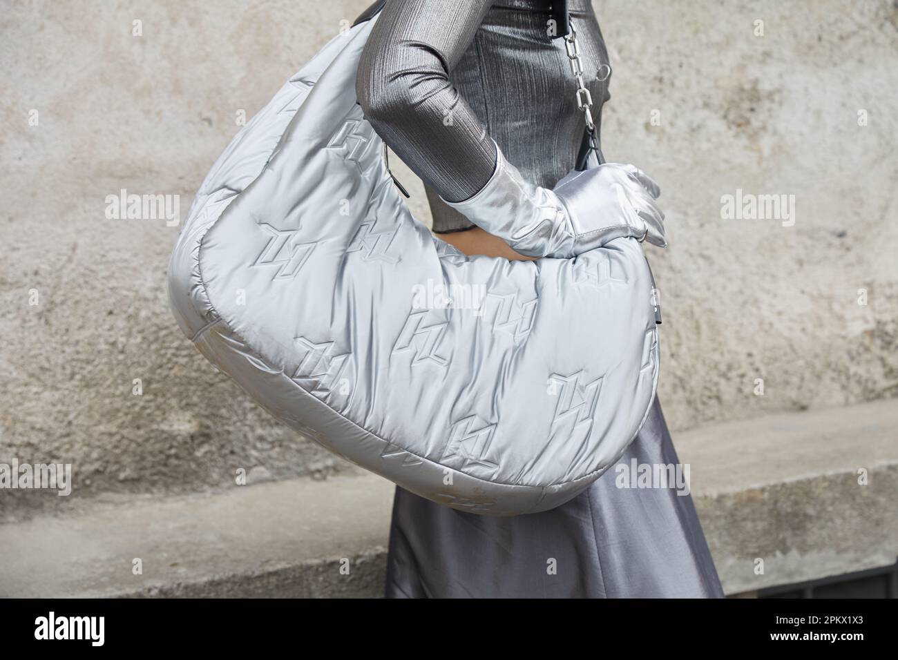 MAILAND, ITALIEN - 23. FEBRUAR 2023: Frau mit Silbertasche und Handschuhen vor der Prada-Modenschau, Mailand Fashion Week Street Style Stockfoto