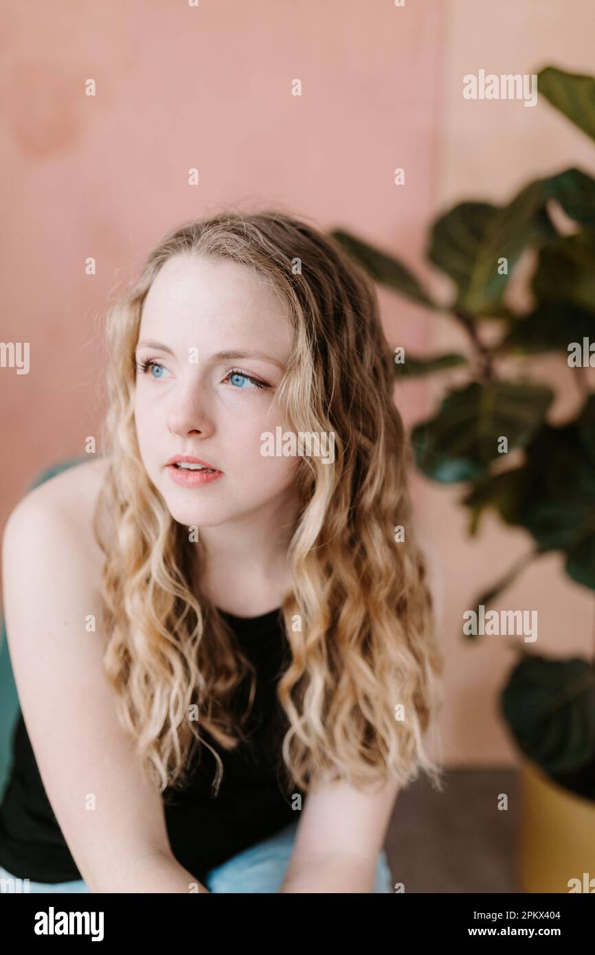 Porträt einer attraktiven jungen Frau vor pinkfarbenem Hintergrund Stockfoto