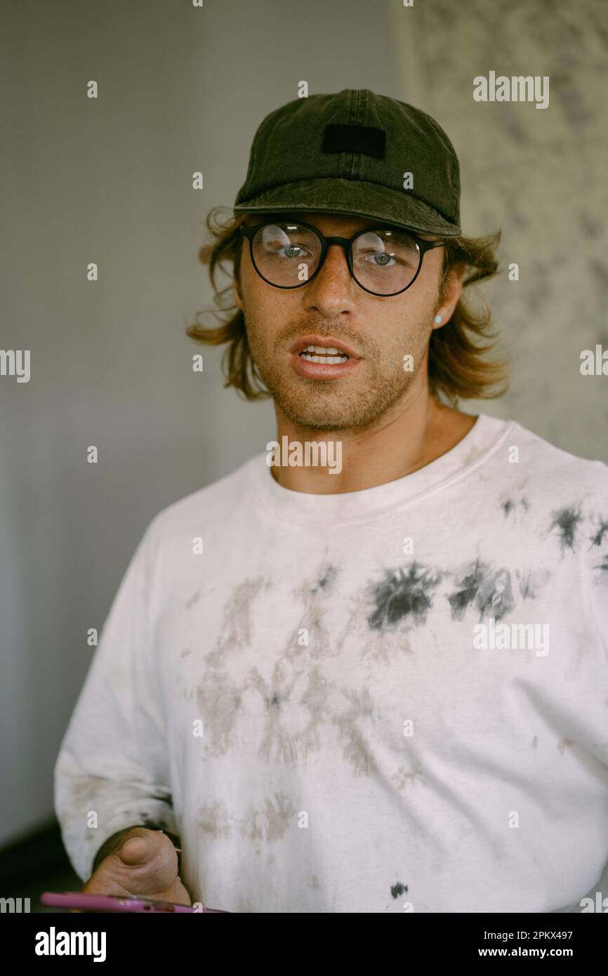 Porträt eines jungen, stilvollen Mannes mit Brille und Mütze. Stockfoto