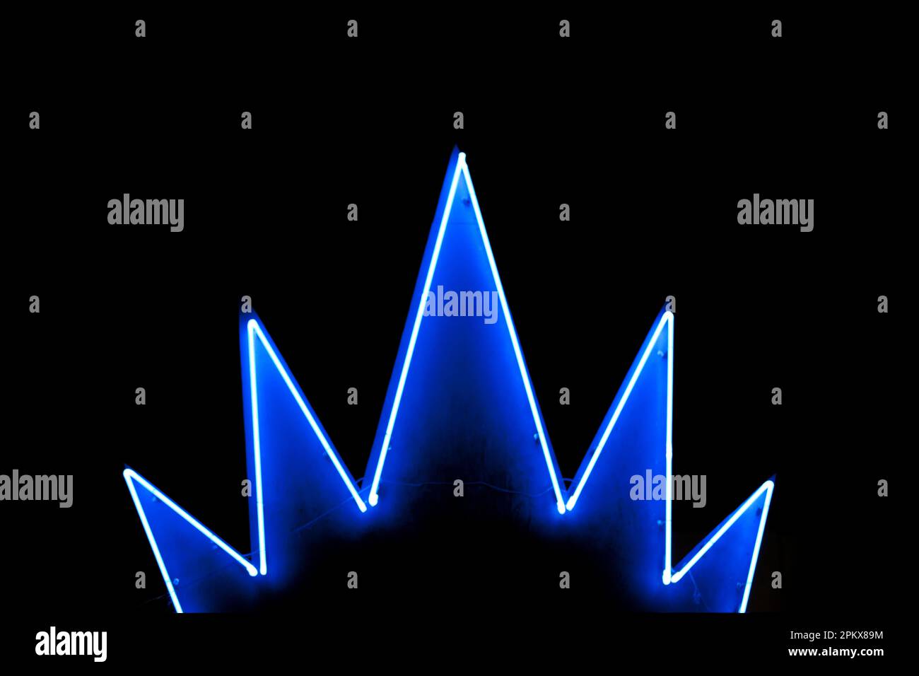 Ein blaues Neonlicht in Form einer Krone, isoliert auf schwarzem Hintergrund. Stockfoto