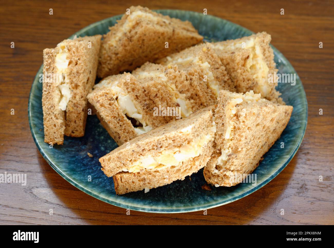 Ein Teller mit Mayonnaise-Sandwiches. Braunes Brot ohne Krusten. Stockfoto
