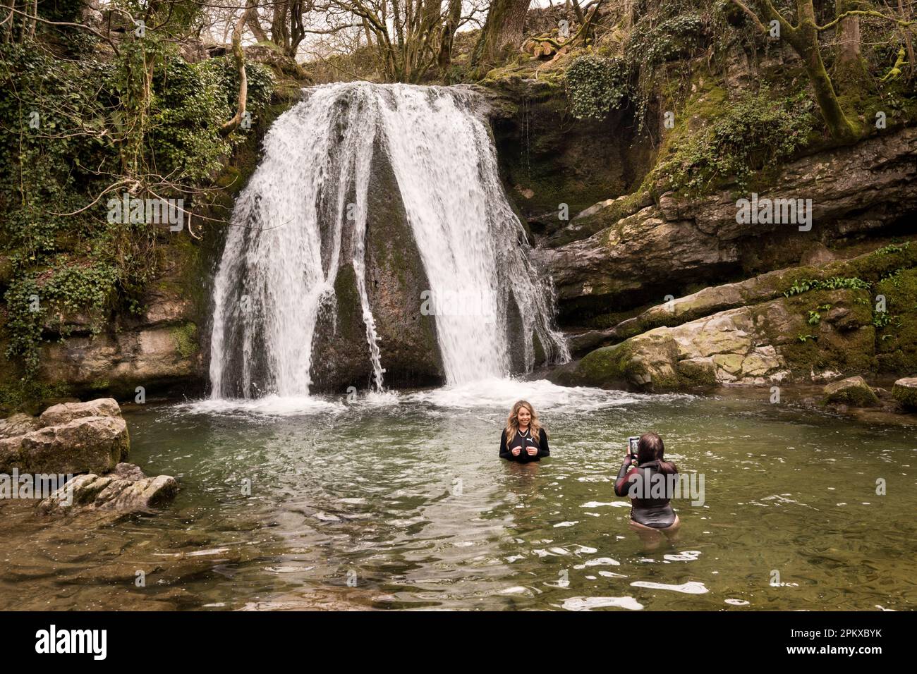 Wilde Schwimmer machen Fotos im kalten Wasser unter dem Janet's Foss Wasserfall, Malham, Yorkshire Dales National Park, Großbritannien Stockfoto