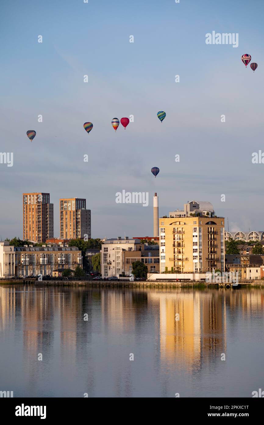 Heißluftballons schweben an der Skyline von Südost-London vorbei und über die Themse als Teil der Ballonregatta des Oberbürgermeisters in den frühen Mornien Stockfoto