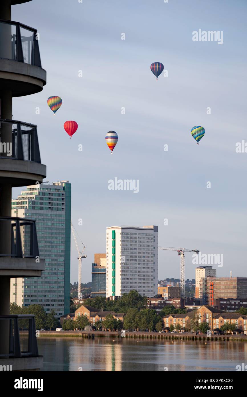 Heißluftballons schweben an der Skyline von Südost-London vorbei und über die Themse als Teil der Ballonregatta des Oberbürgermeisters in den frühen Mornien Stockfoto