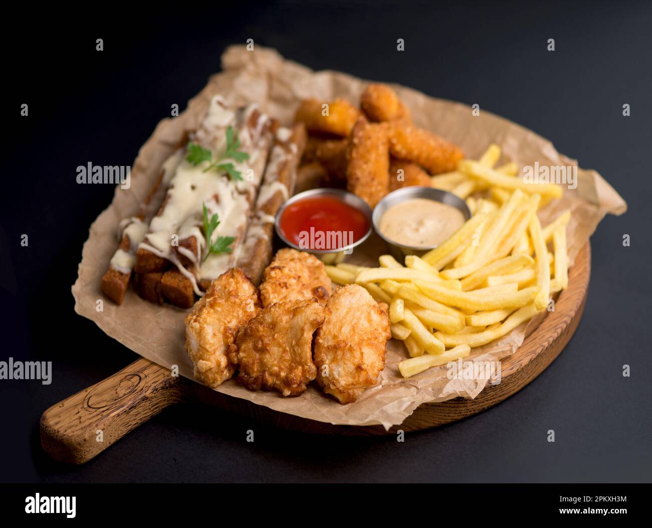 Große Auswahl an Snacks für Bier mit verschiedenen Soßen auf Pergament, Ansicht von oben Stockfoto