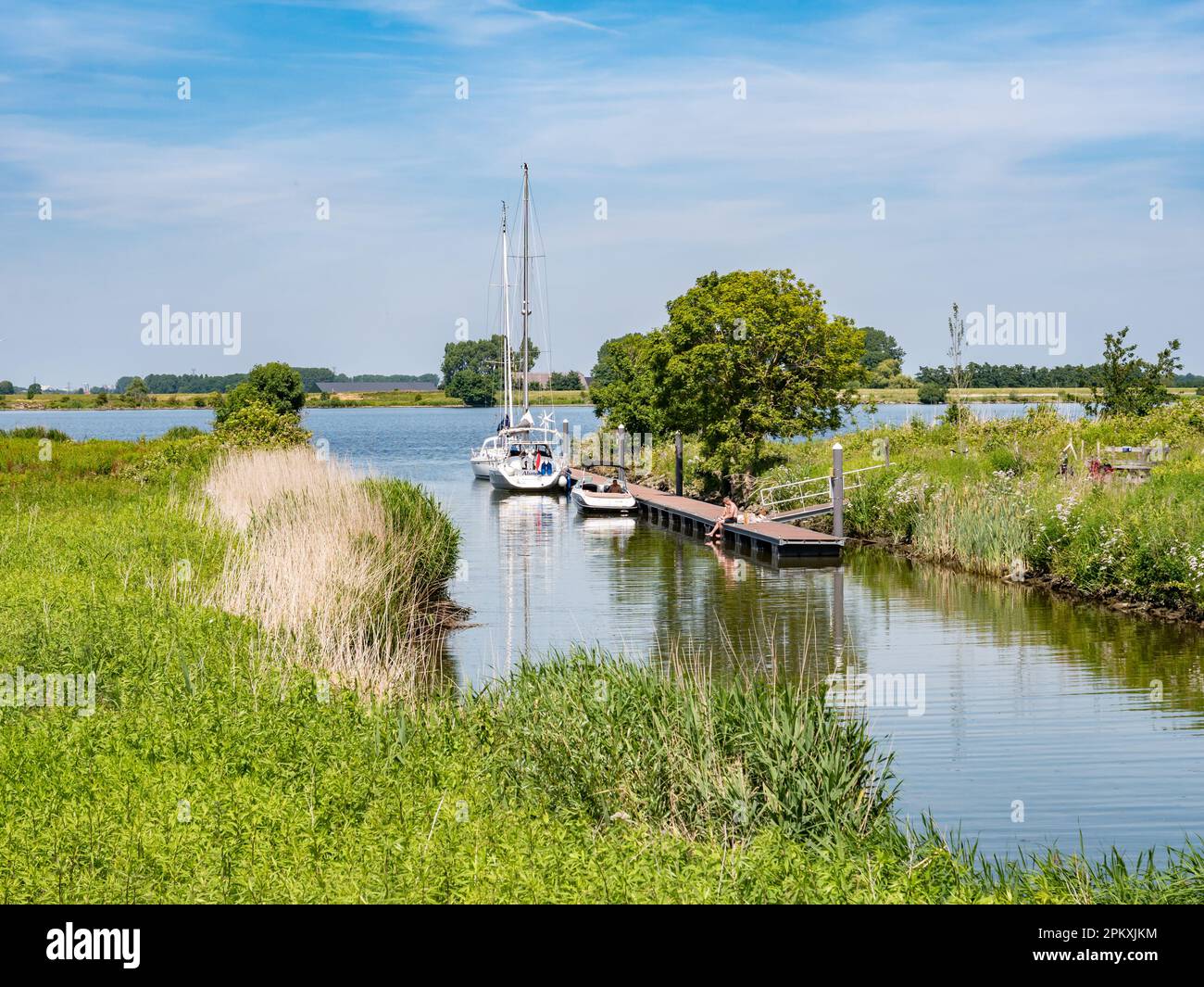 Kleiner Hafen mit Booten an der Anlegestelle auf der Insel Tiengemeten in der Haringvliet-Mündung, Südholland, Niederlande Stockfoto