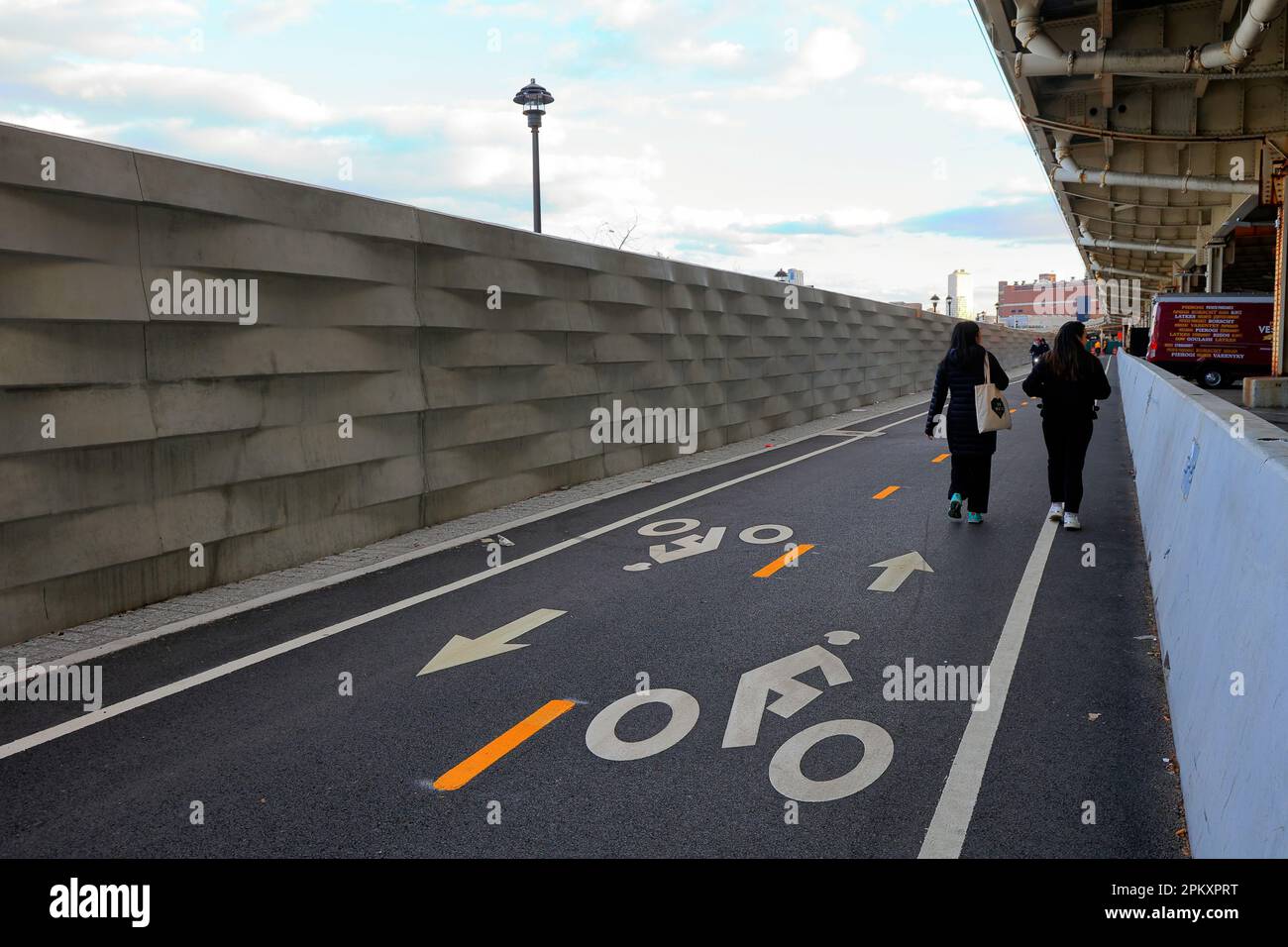 Menschen, die entlang eines Abschnitts des East River Greenway in Stuyvesant Cove laufen, mit fertiggestellten 8 Fuß hohen Überschwemmungen, die die ... (Weitere Informationen) Stockfoto