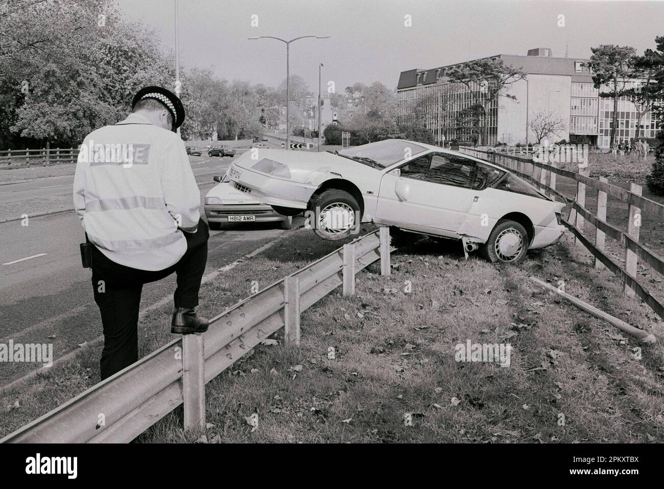 Ein Crash Mitte 90s Renault Alpine balanciert auf der Absperrung neben der Ringstraße in Salisbury, Wiltshire, Großbritannien. Ungefähr 1995. Es wurden keine Verletzungen erlitten. Stockfoto