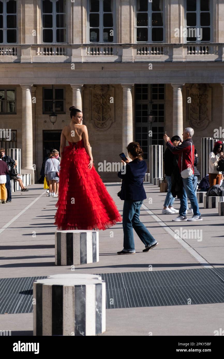 Woman in Red Dress posiert auf Schwarz-weiß-Säulen, aufgenommen von einem professionellen Fotografen in Paris Special Setting Stockfoto